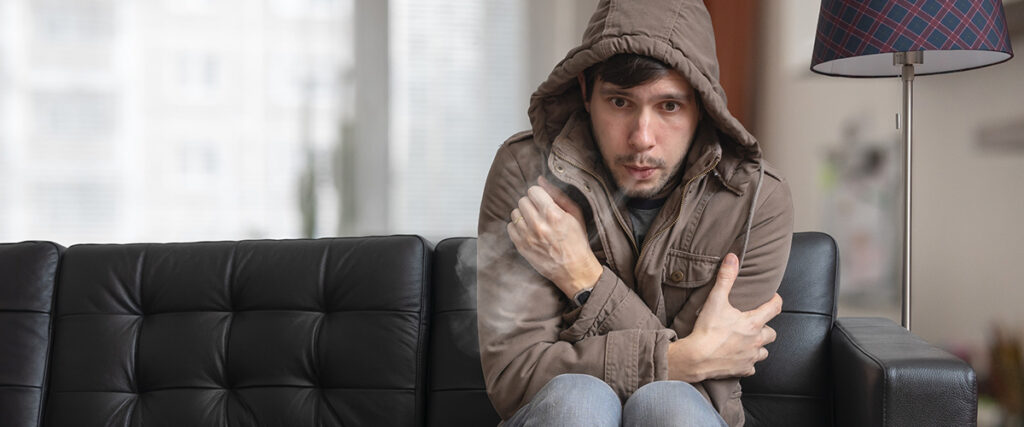 Cold Weather in Georgia: Keeping Your Home Warm and Efficient This Winter - shivering man sitting on sofa